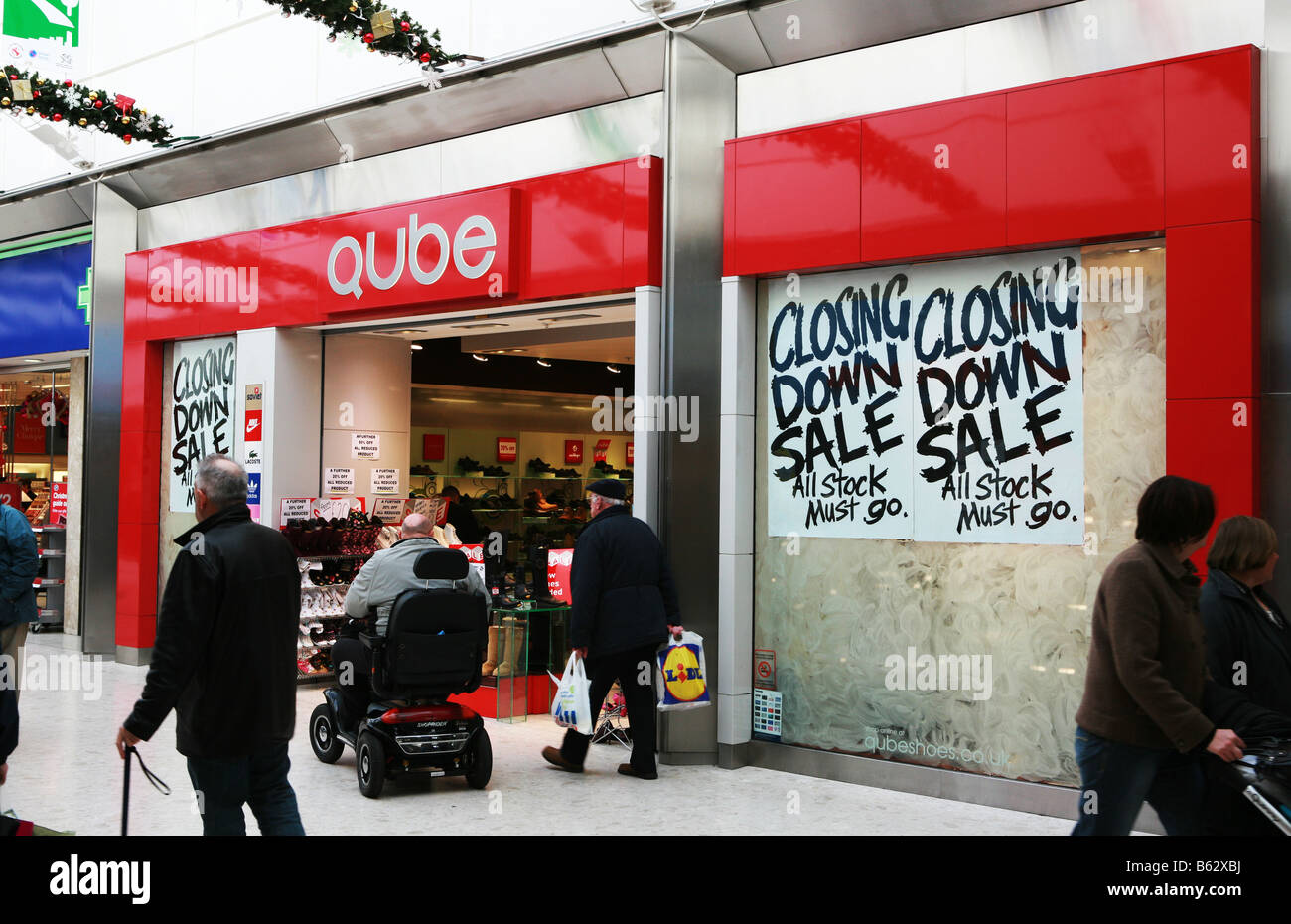 UK highstreet shopping centre mall retail shop outlet with closing down sale all stock must go sign in window recession victim Stock Photo