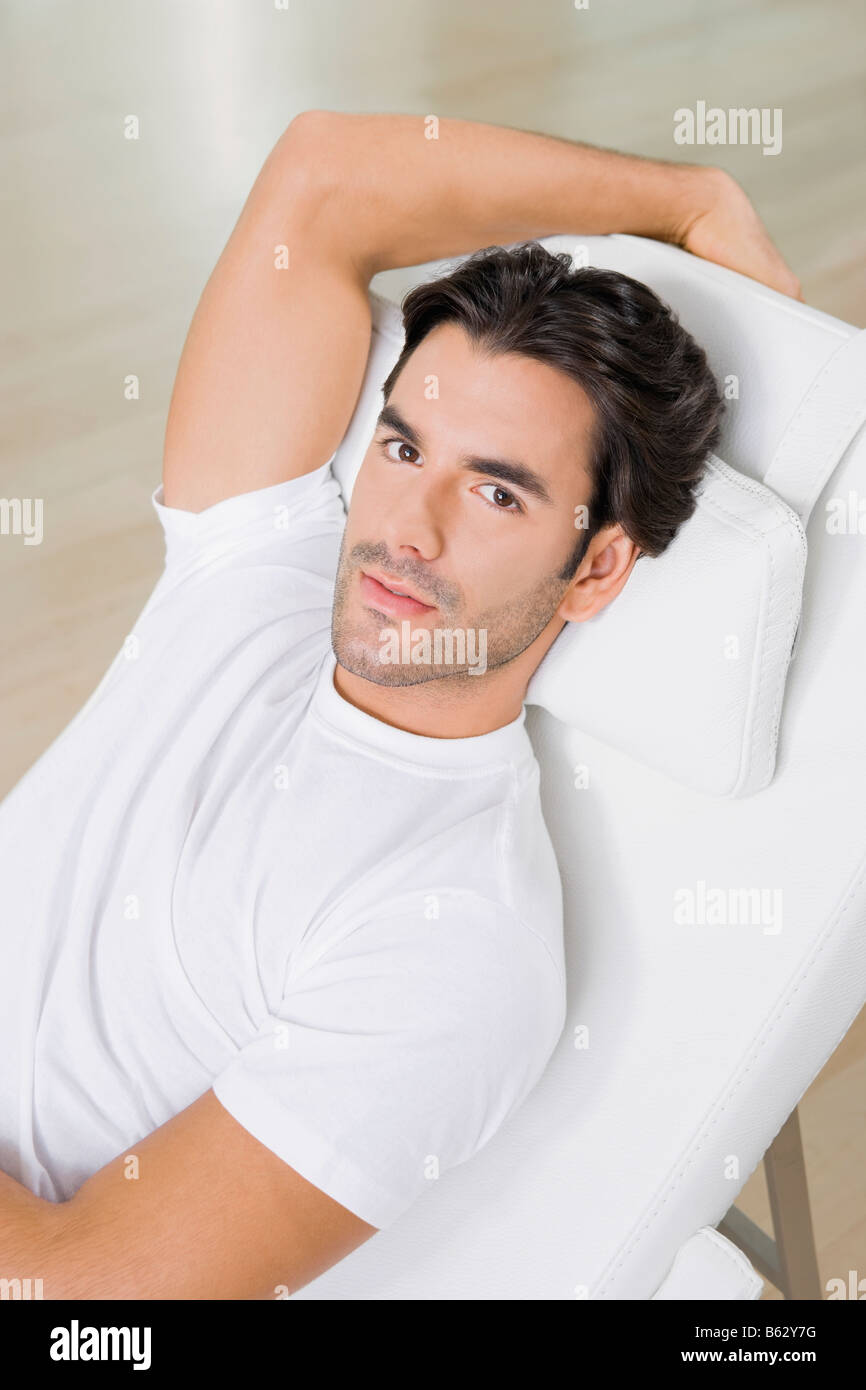 Portrait of a young man resting on a reclining chair Stock Photo - Alamy