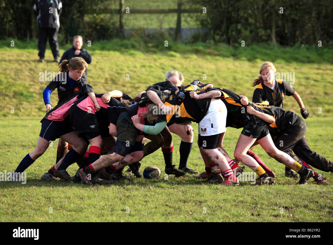 Teenage girls playing Rugby on a cold wet autumn afternoon Stock Photo