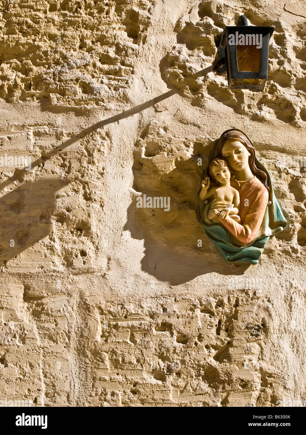 Madonna and baby Jesus icon on wall with lamp Stock Photo