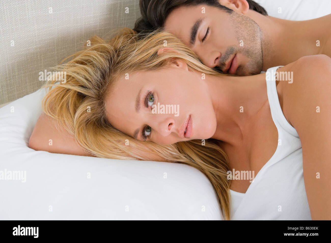 Mid adult woman and a young man lying on the bed Stock Photo - Alamy