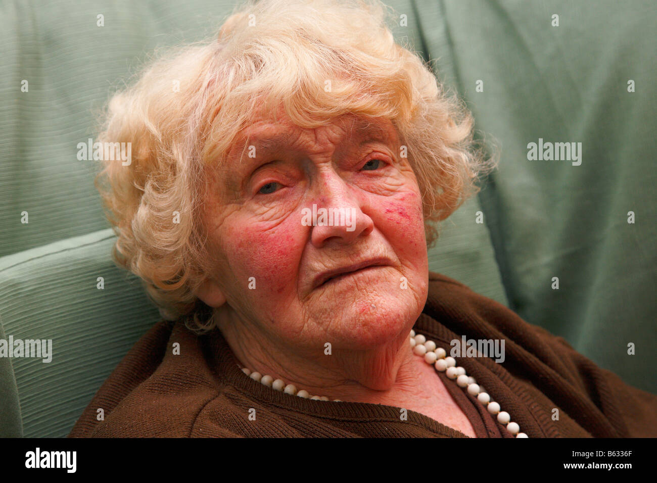 Old woman sitting in a chair Stock Photo