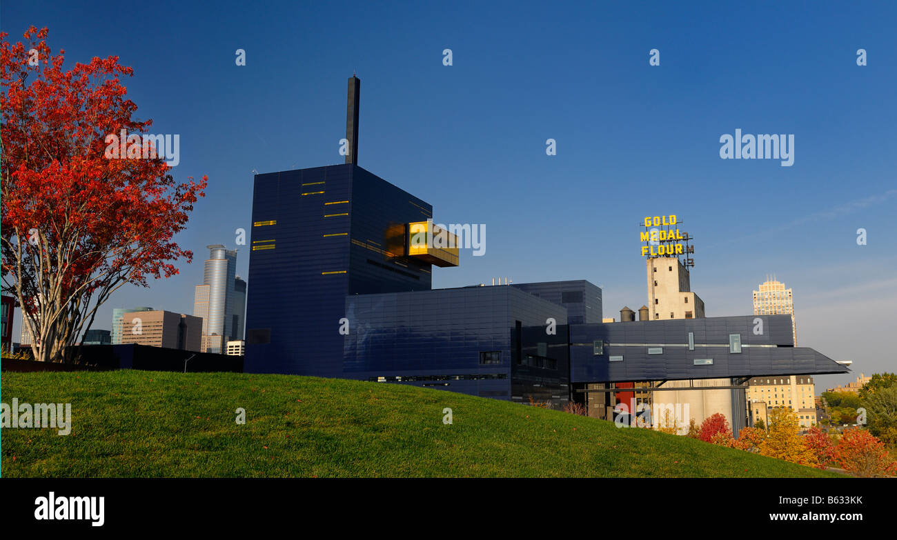 Panorama of Blue Guthrie Theater in Minneapolis Mill City Historic District with Gold Medal Flour silos and red Autumn maple tree Stock Photo