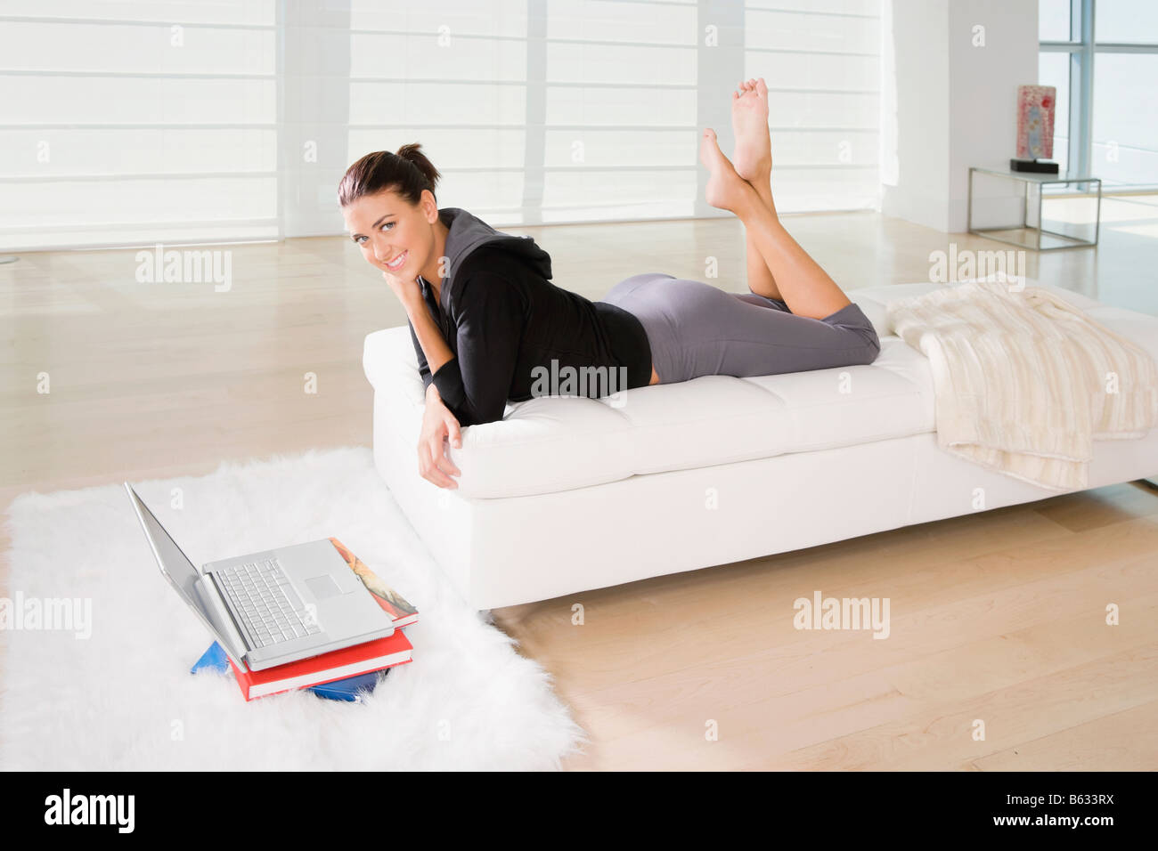 Portrait of a young woman lying on the bed and smiling Stock Photo - Alamy