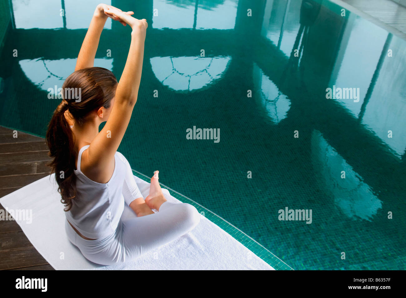 Young woman exercising at the poolside Stock Photo