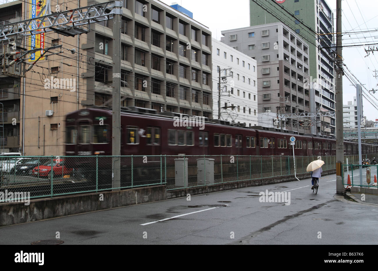 Hankyu-line electric train passing city suburb in Osaka, Japan. Stock Photo