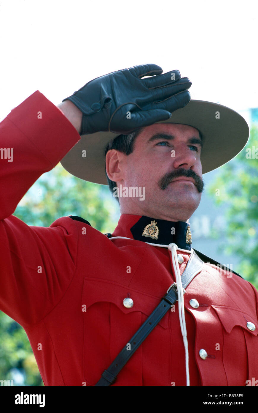 A Canadian Mountie (RCMP) Royal Canadian Mounted Police Officer saluting  and wearing Traditional Red Surge Uniform Stock Photo - Alamy