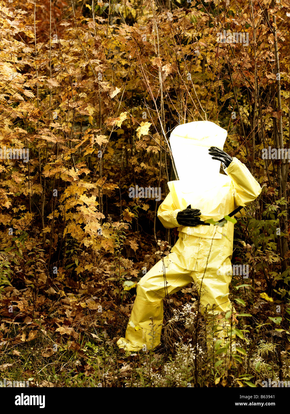 43 year old asian male in a hazmat suit and gas mask outdoors with the fall colours and foliage Stock Photo