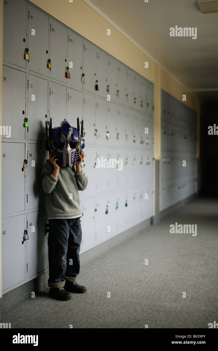 Boy in school corridor wearing Transformer robot mask Stock Photo