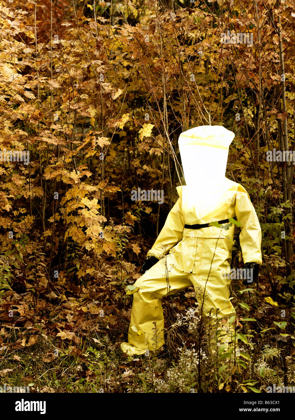 43 year old asian male in a hazmat suit and gas mask outdoors with the fall colours and foliage Stock Photo