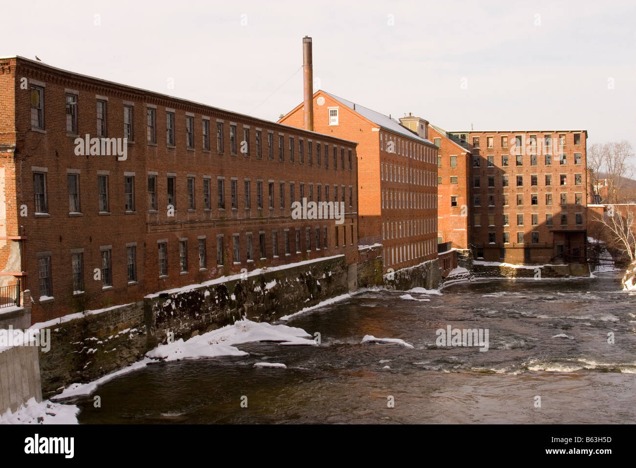 Old factory buildings on the shore of the Sugar River in Claremont, New Hampshire. Stock Photo