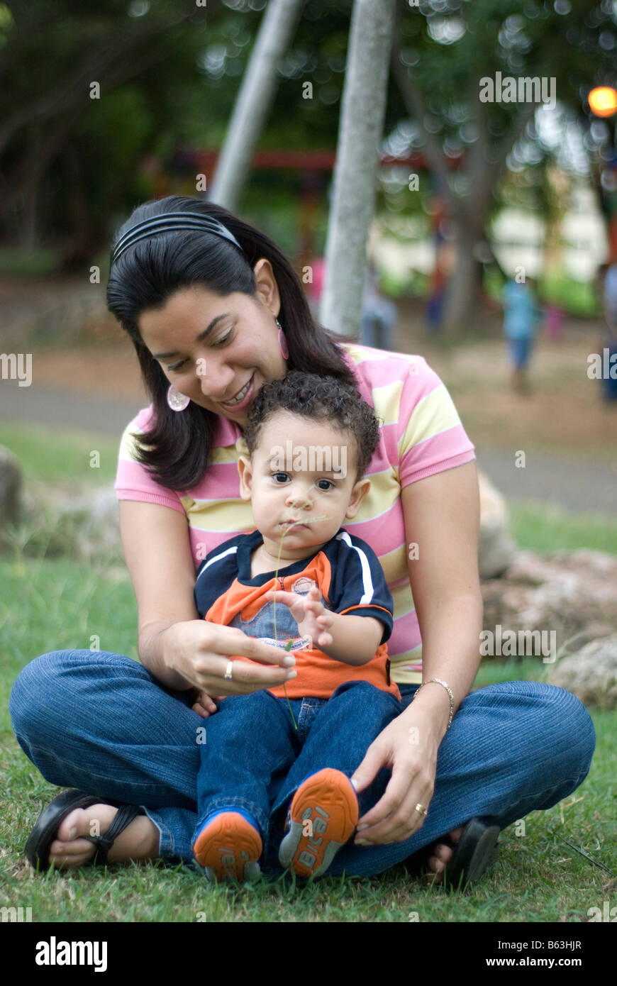 A little Latin toddler receives a weed from his mother during a day in ...