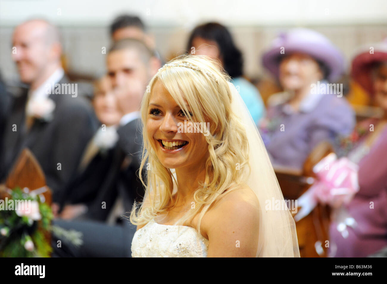 A bride sits at the front of the church before getting married Stock