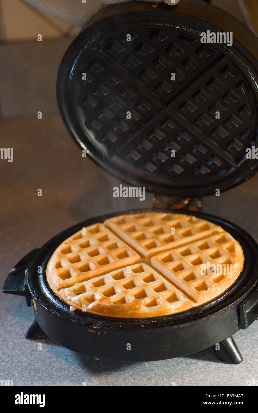 Waffle being made on waffle iron Stock Photo Alamy