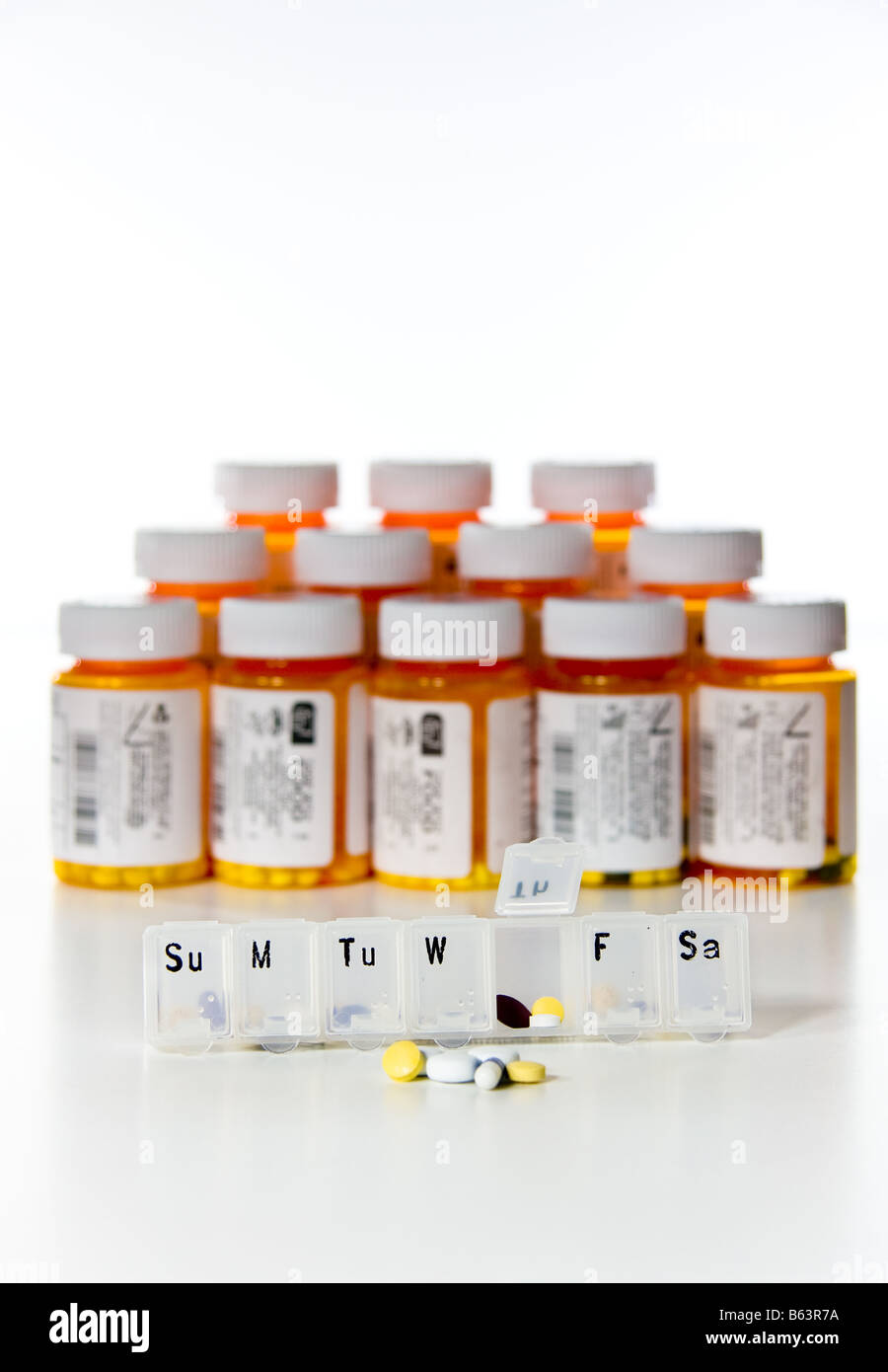 Vertical row of drug medicine bottles with weekly reminder Stock Photo