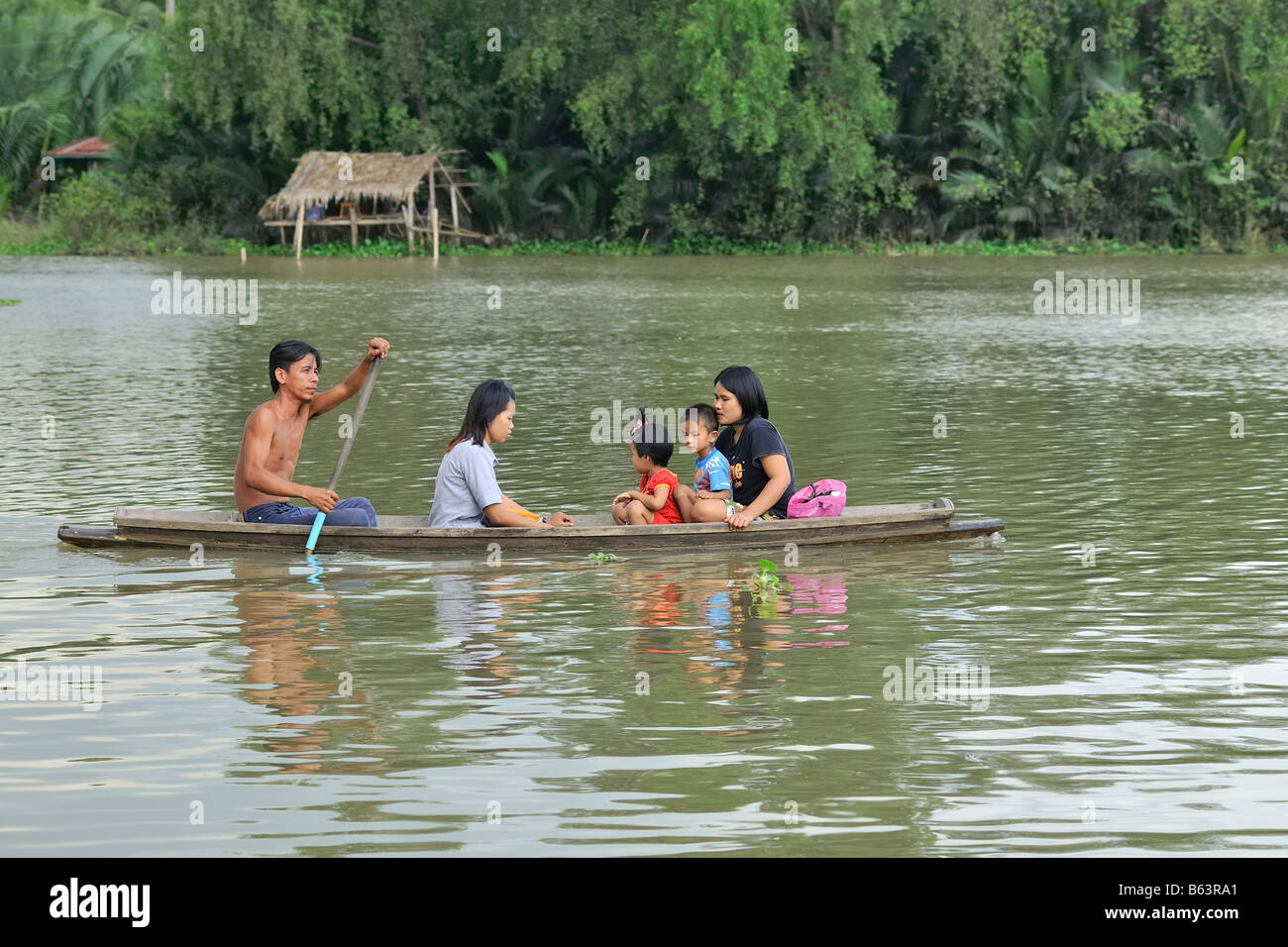 A happy thai family in a traditional rowing boat near the city of ...