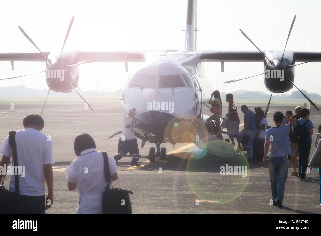 Tourists walking towards passenger aircraft, Clark Airport, Angeles City, Philippines Stock Photo