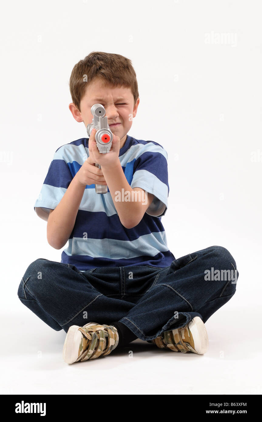 Young boy holding a toy gun Stock Photo