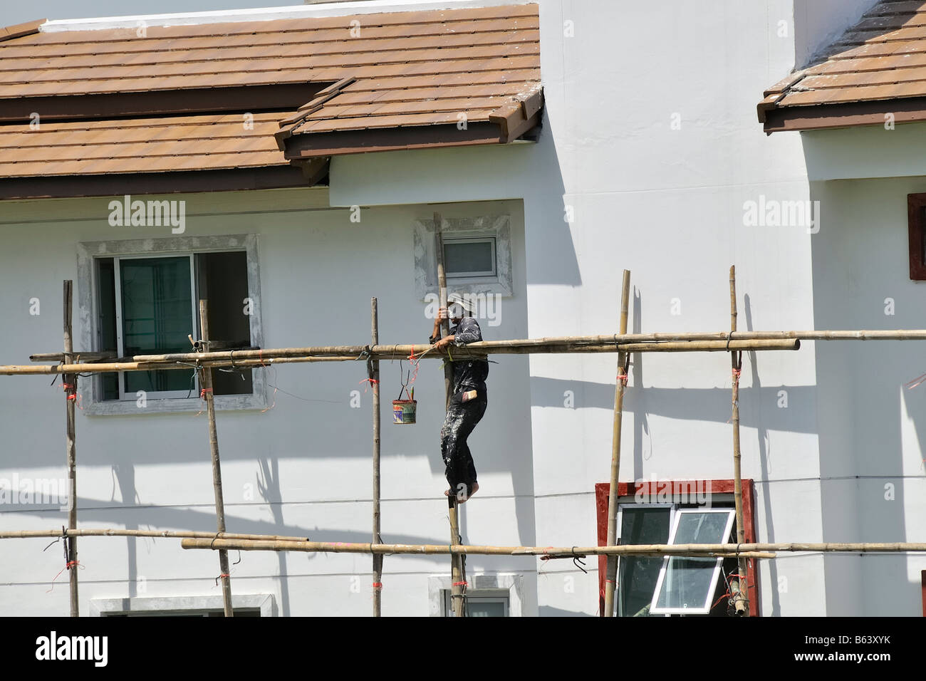 Working safety. Bamboo scaffold is still used frequently in Asia, and workers mostly only wear slippers instead of safety shoes Stock Photo
