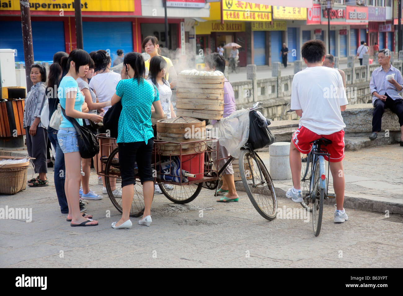 Chinese woman selling his freshly baked bread on the street of Yangshuo, China Stock Photo