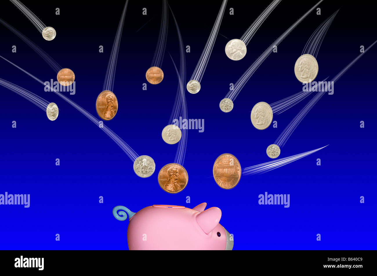 Coins falling into a pink piggybank on blue background Stock Photo - Alamy