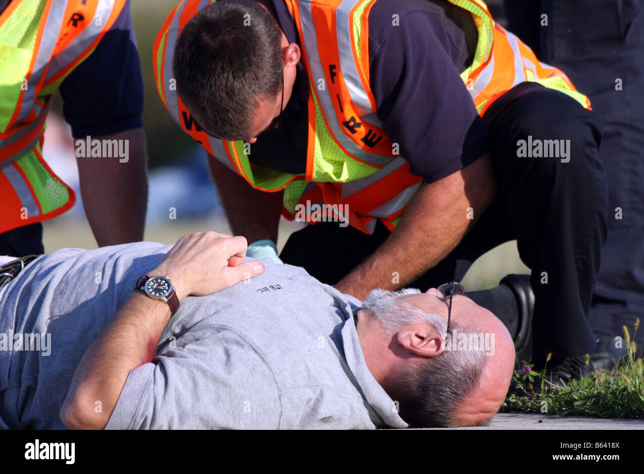 During the chaos of a mass casualty scene EMS personnel leaning over an ...