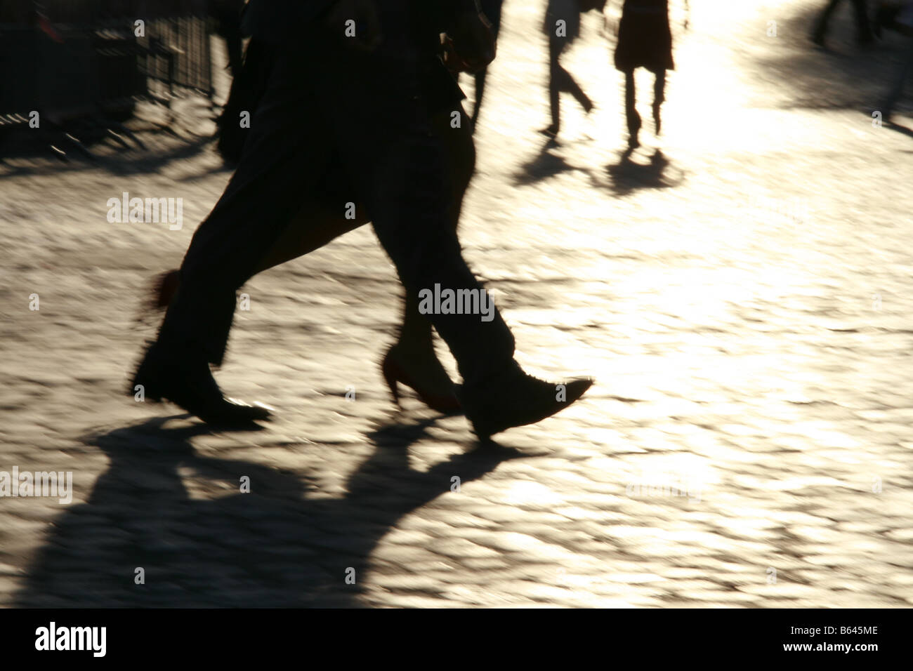 shadow person fast speed feet legs walking in street in town Stock Photo