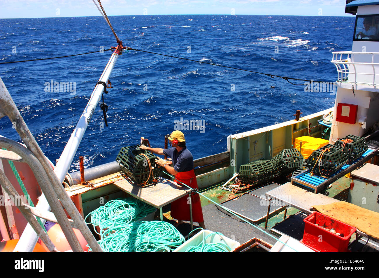 a deckhand at work on a deep sea crab fishing vessel Stock Photo