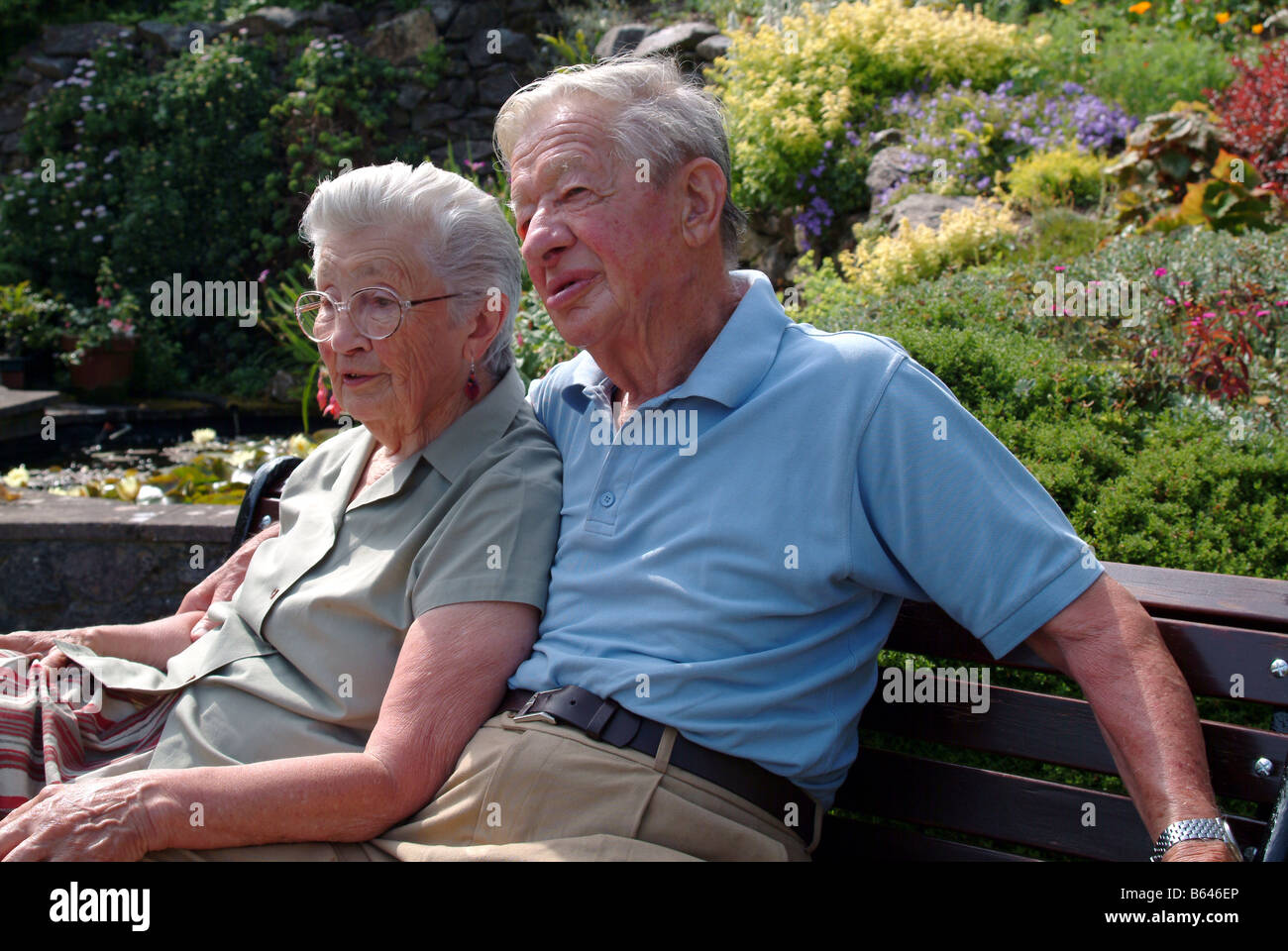 Elderly couple sitting on a bench and relaxing together Stock Photo - Alamy