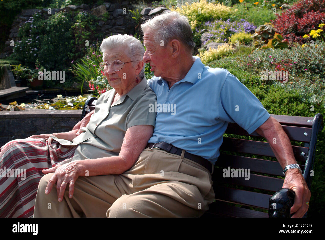 Elderly couple sitting and relaxing on a bench together Stock Photo - Alamy