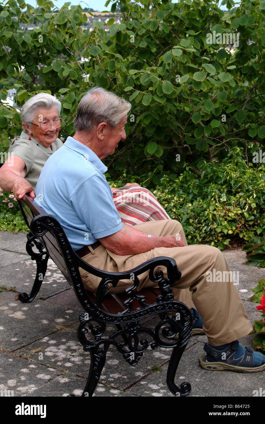 Elderly couple relaxing together on a bench Stock Photo - Alamy