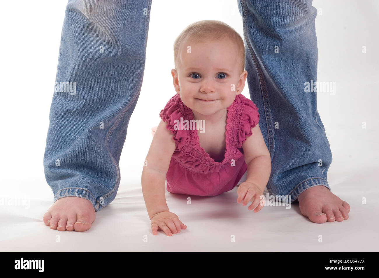 Baby girl crawling between legs Stock Photo Alamy