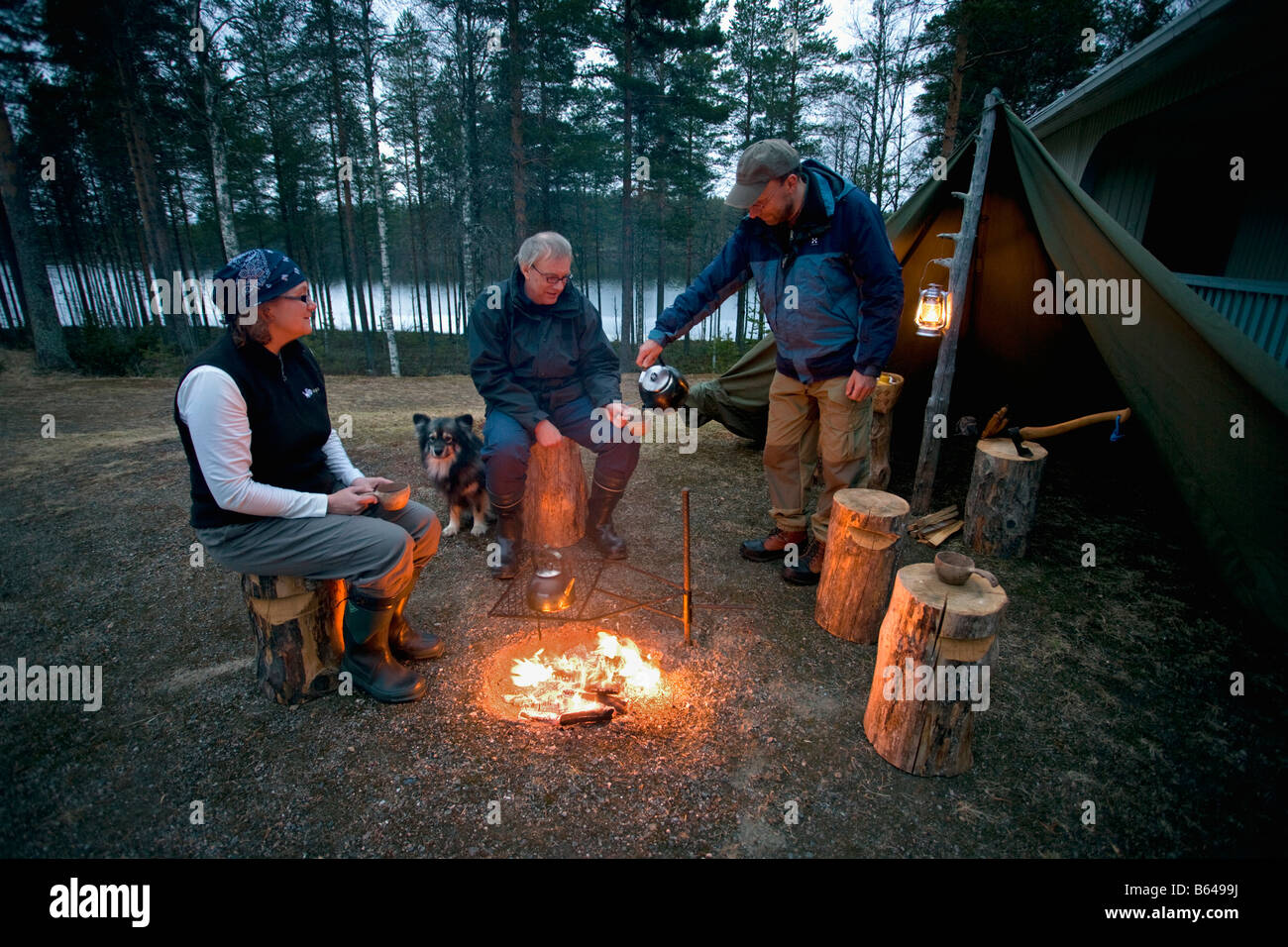 Finland, Kuikka Lake, near Kuhmo. Ultima taiga. Centre for tourism, Enjoying evening at campfire. Stock Photo