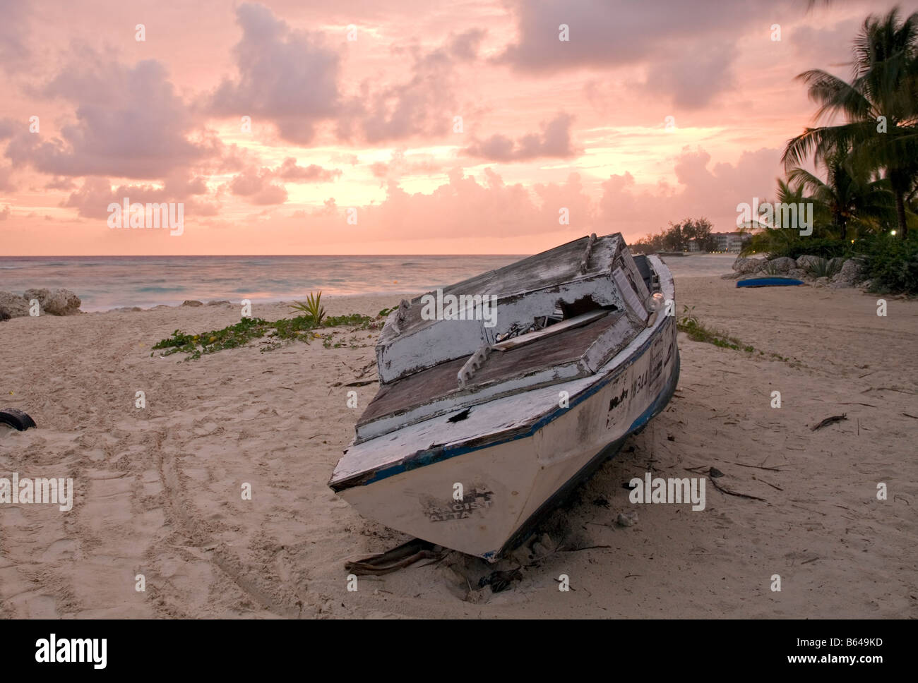 sunset over beached boat on Sandy Bay Worthing Barbados Caribbean Stock Photo