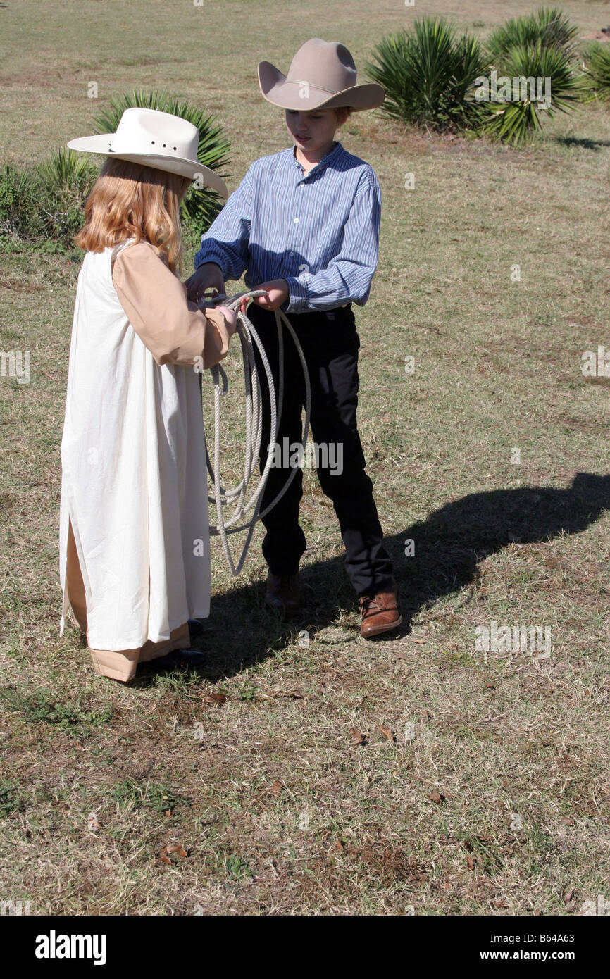 A young cowboy is teaching a young girl how to throw a rope Stock Photo ...