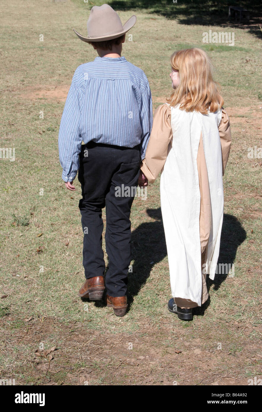 A young cowboy holding the hands of a young girl Stock Photo - Alamy