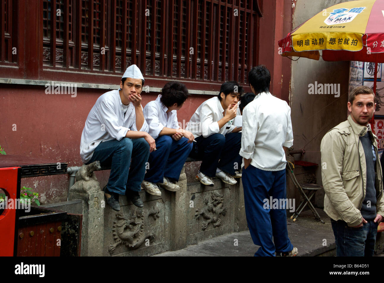 Young cooks taking a well deserved cigarette break after a busy lunch hour in City God Temple tourist and shopping area Stock Photo