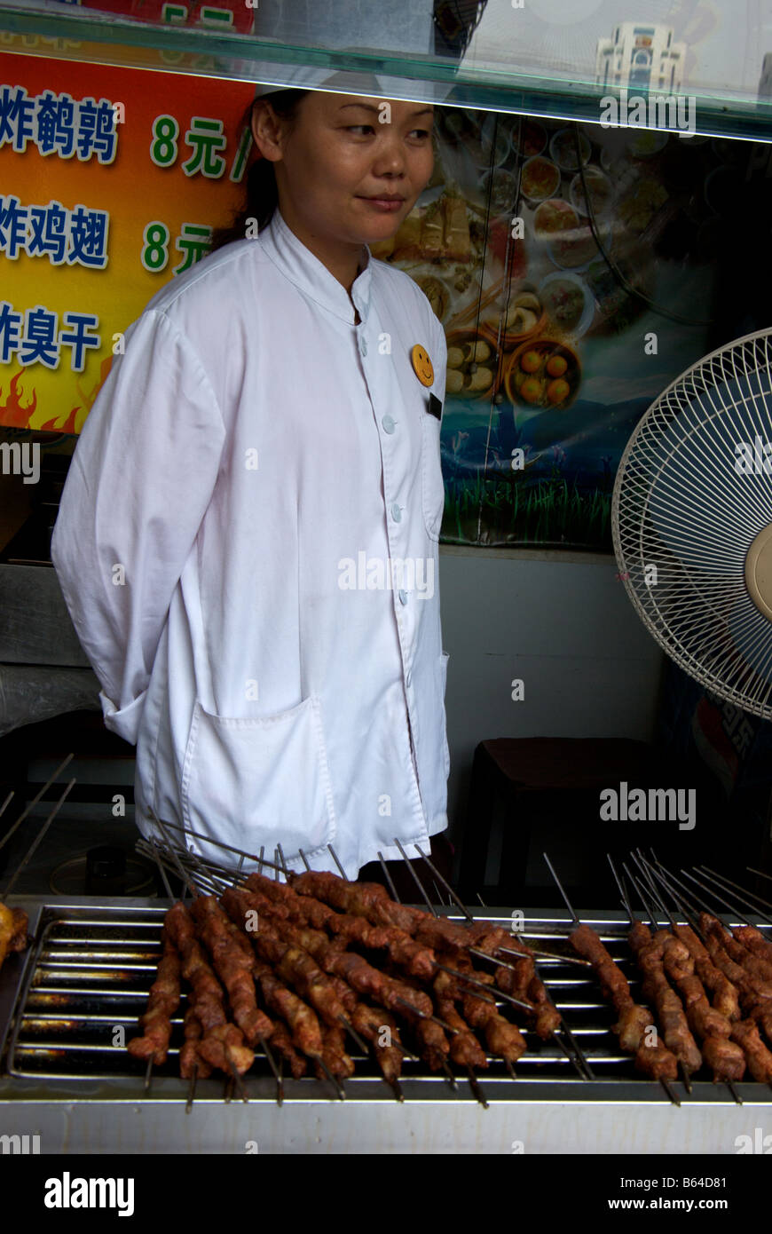 Vendor cook selling barbecue grilled meats at food stall off Shanghai's Old Street in former City God Temple Stock Photo