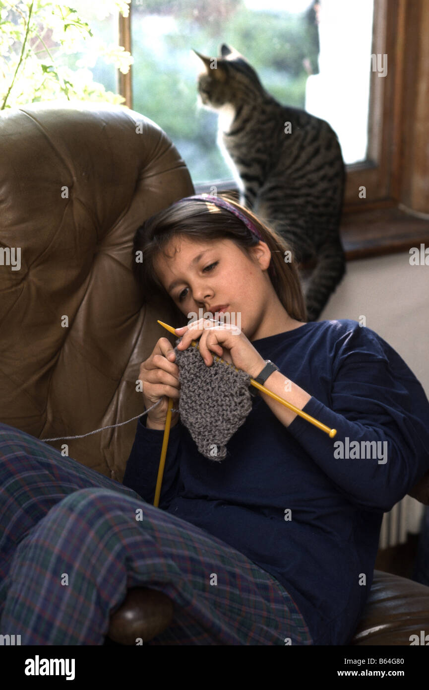 teenager knitting lounging in a comfortable chair Stock Photo
