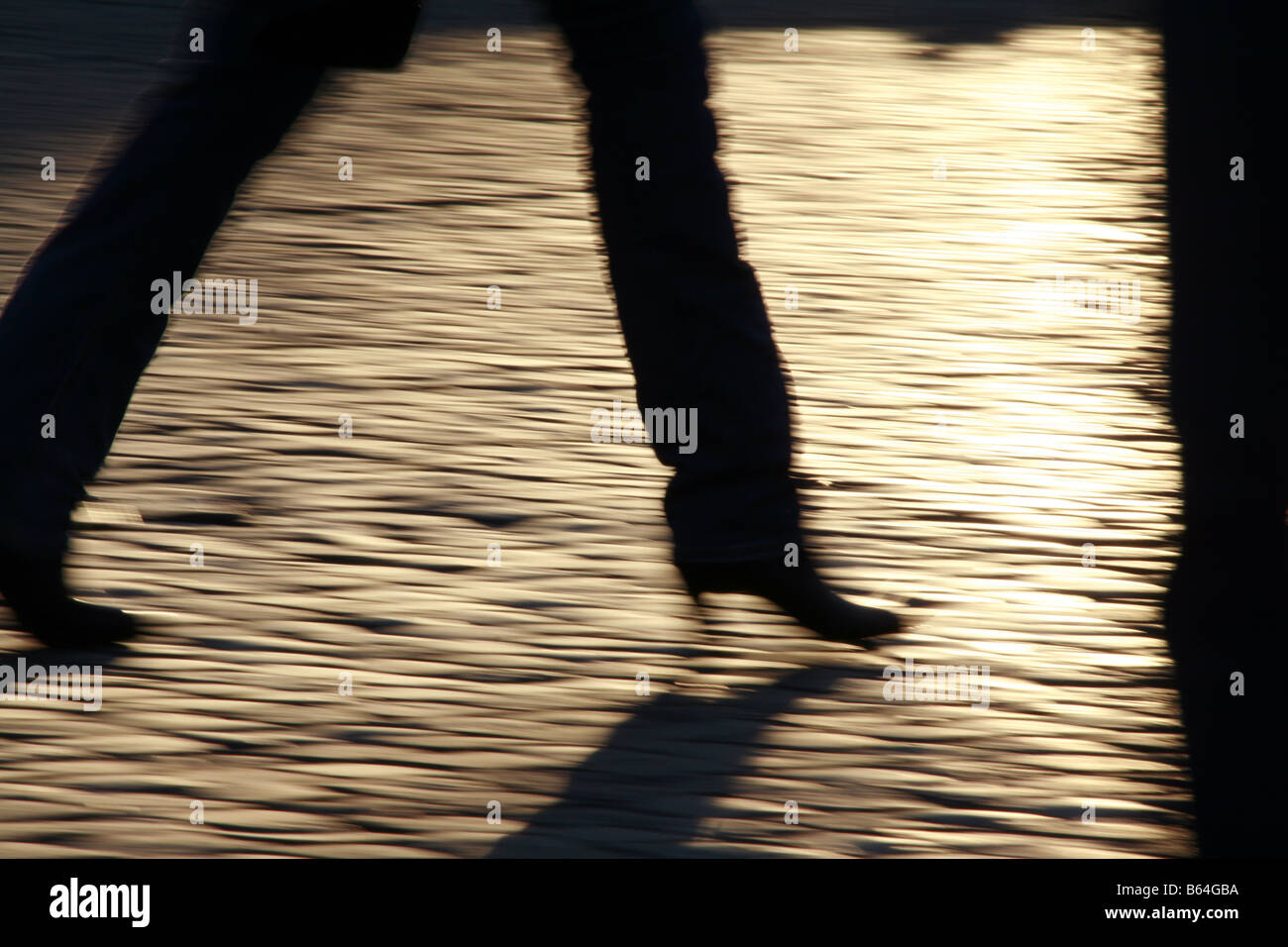 shadow person fast speed feet legs walking in street in town Stock Photo