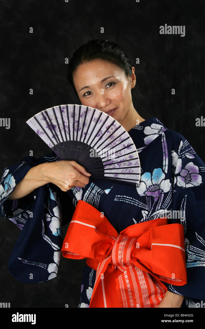 Japanese Woman in a Blue Kimono with a Fan. Stock Photo