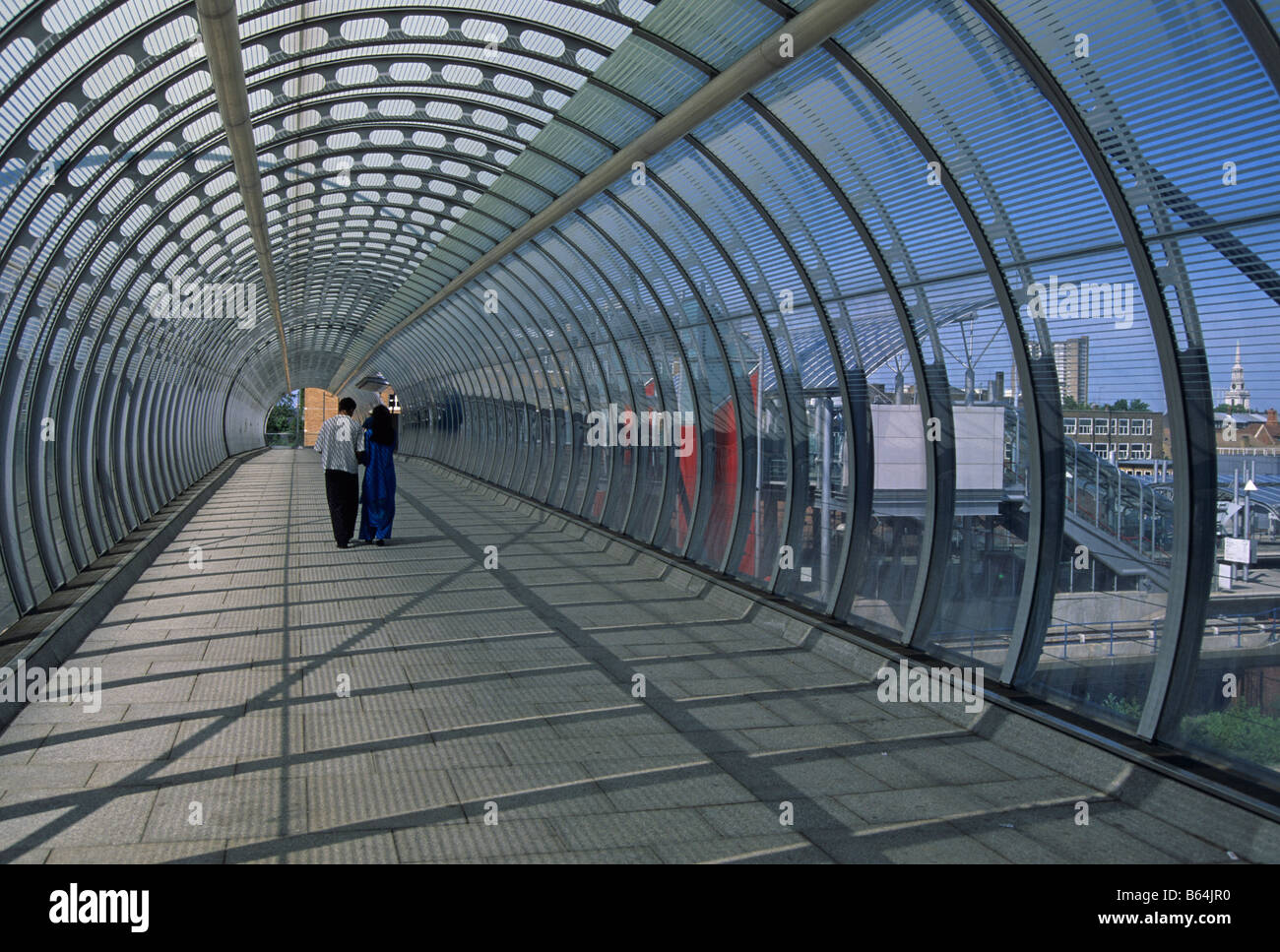 Asian couple in the footbridge tunnel of Poplar DLR station London docklands England Stock Photo