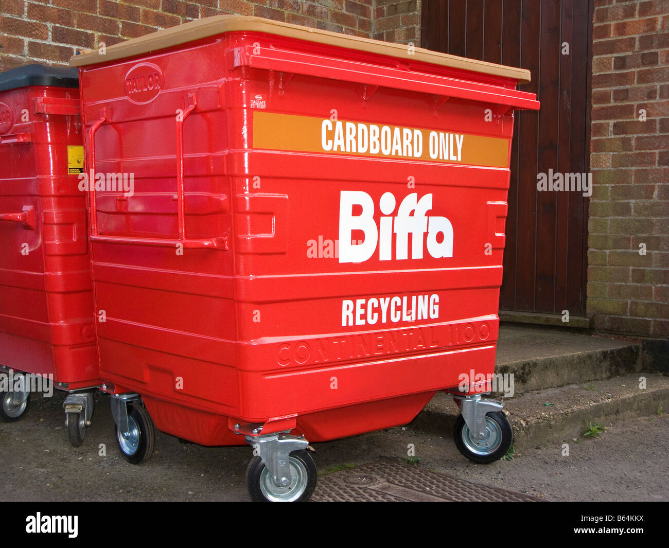 Large Red Industrial Recycling Bins Situated Behind Retail Units Stock