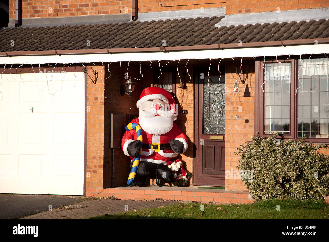 A blow up Father Christmas character in the porche of a modern house