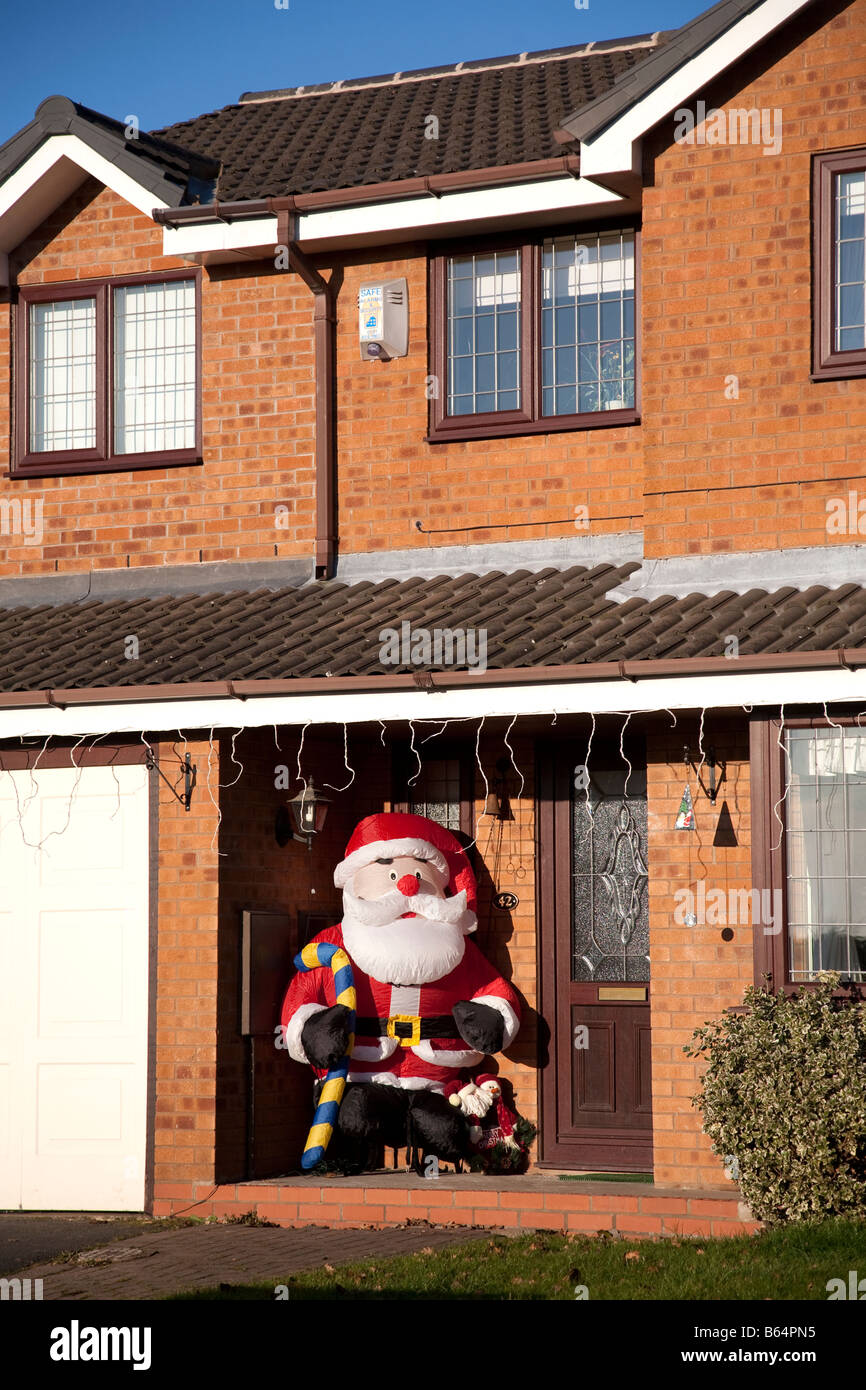 A blow up Father Christmas character in the porche of a modern house