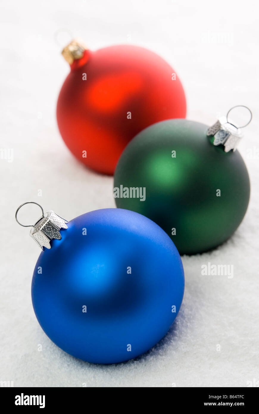 Red, Green and Blue christmas balls on the snow. aRGB. Stock Photo