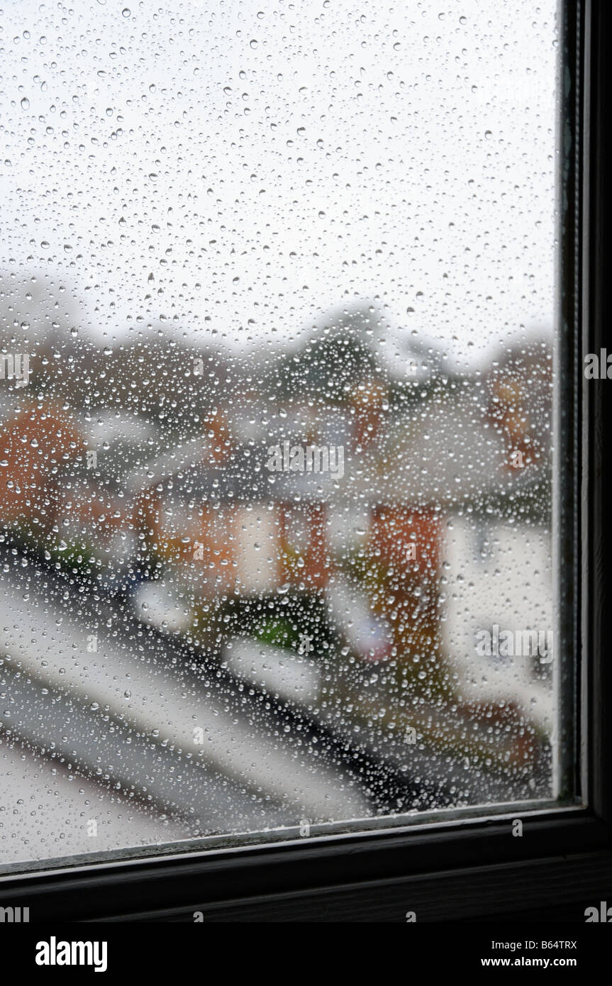 A row of houses seen through raindrops on a window during a rain storm ...