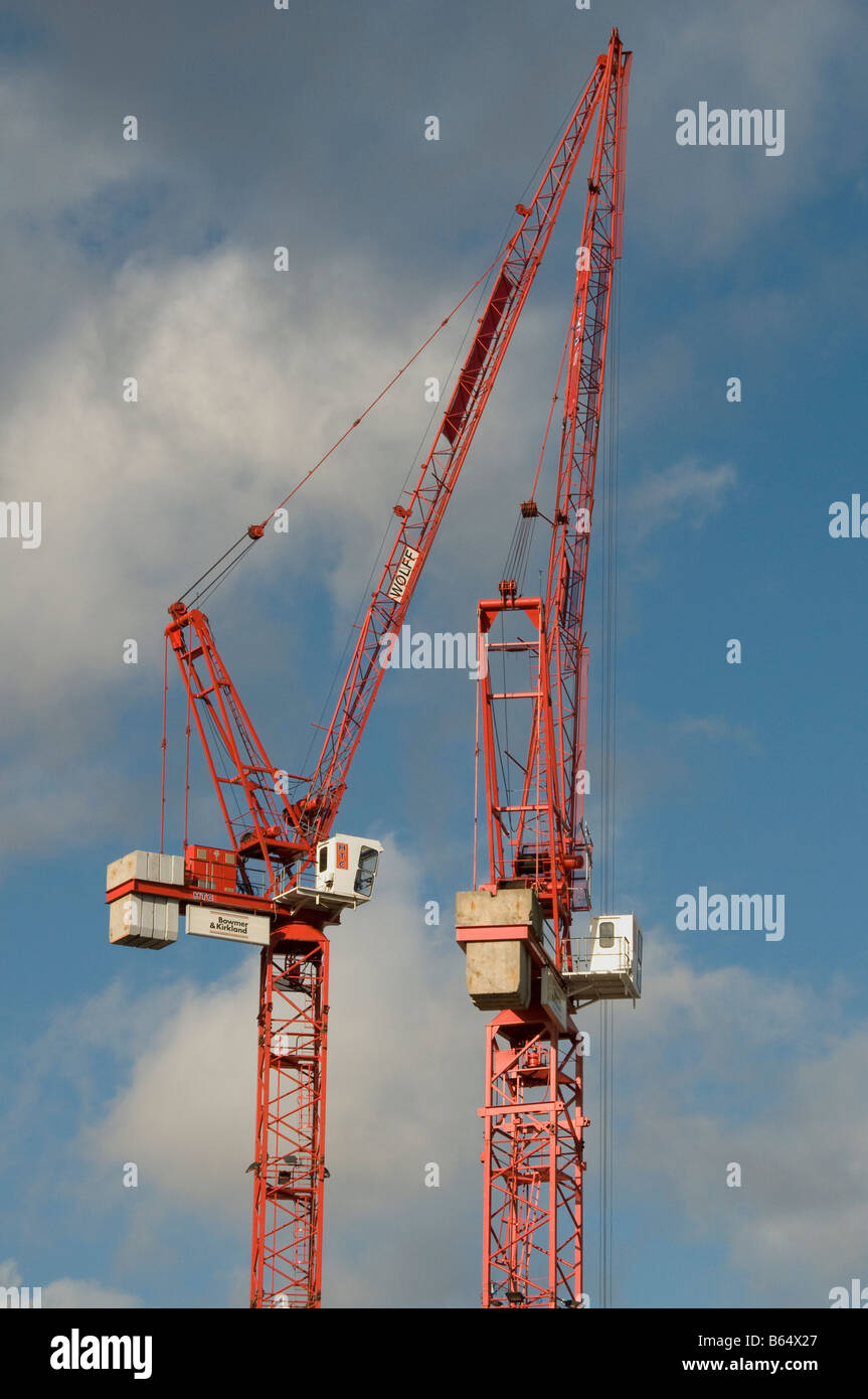Two red cranes against blue sky with white clouds Stock Photo - Alamy