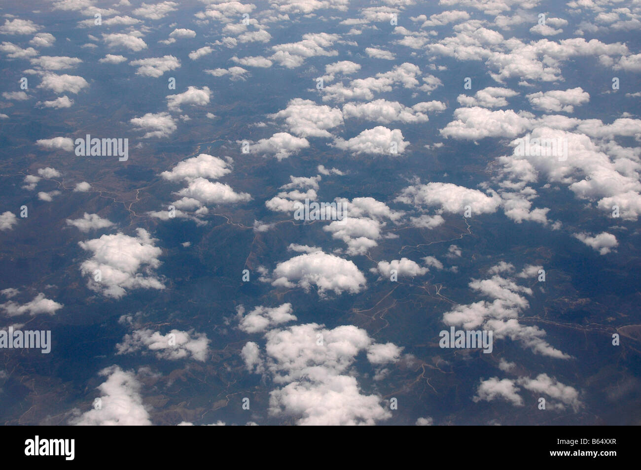 Clouds and land as seen from an airplane. Stock Photo
