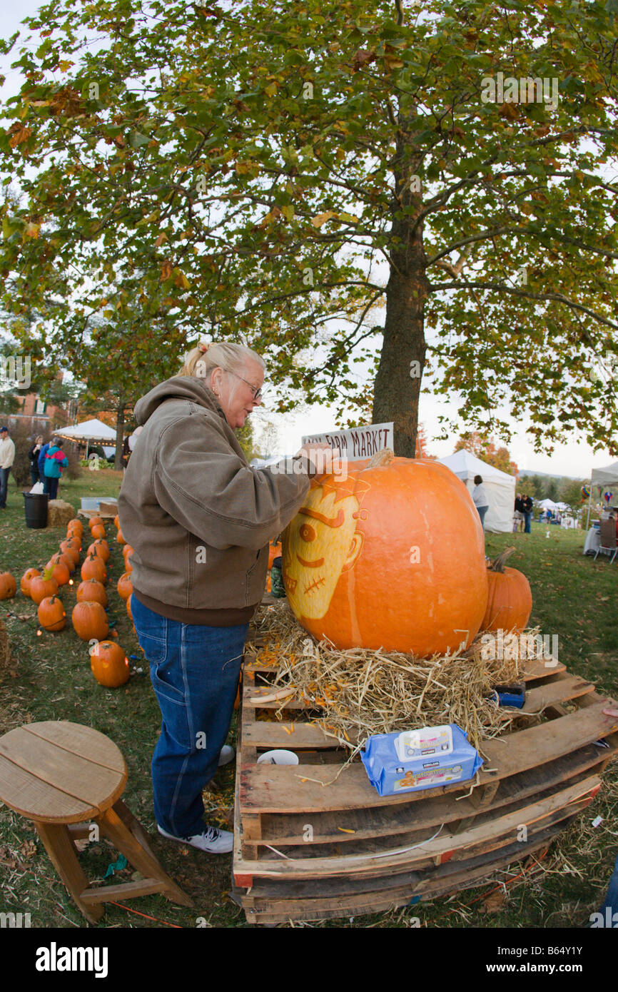 A woman from Nalls Farm Market carves a pumpkin at the 2008 Shenandoah Valley Hot Air Balloon and wine Festival in Millwood, VA. Stock Photo